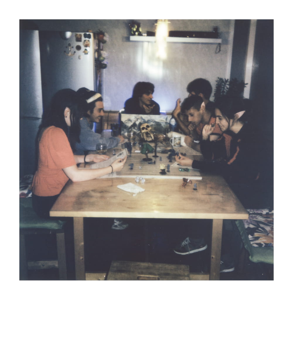 Große Gruppe spielt Dungeons & Dragons zu Hause mit Miniaturen und Meisterschirm